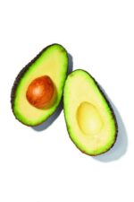 en avocado skåret i to på en hvid baggrund.