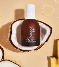 en flaske solfri solcreme ved siden af en opskåret ananas.