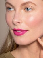 et nærbillede af en kvinde med en pink læbestift.