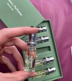 en person, der holder en lille flaske parfume.