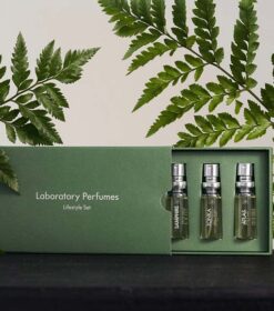 en grøn æske indeholdende tre flasker laboratorieparfumer.