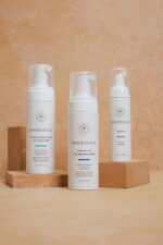 Tre flasker Innersense i Create Lift Volumizing Foam - Styling 177 ml på et bord.