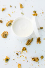 En hvid skål med Innersense Inner Peace Whipped Creme Texturizer - Styling creme 96g med tørrede blomster omkring.