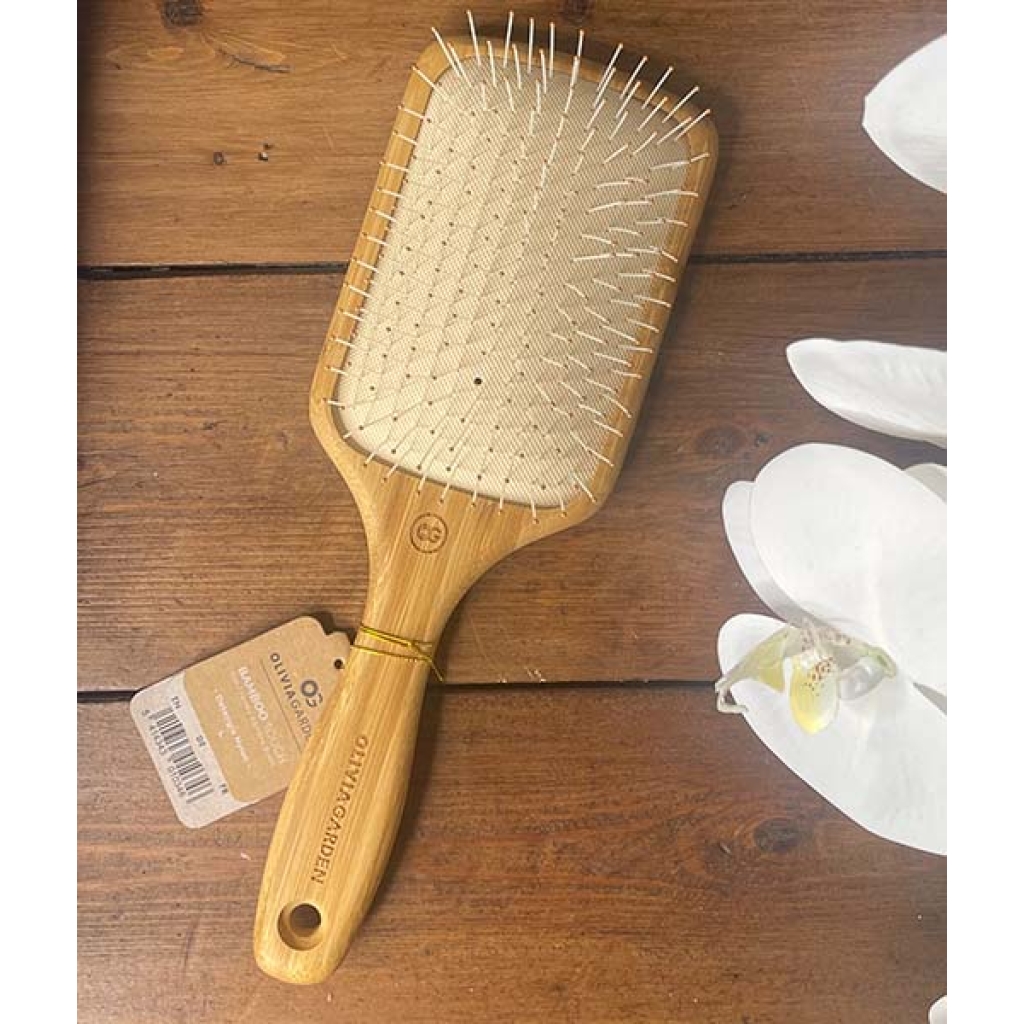 An Olivia Garden – Ionic Bambus Touch hårbørste - Detangle Nylon L - Padlebørste på et træbord.