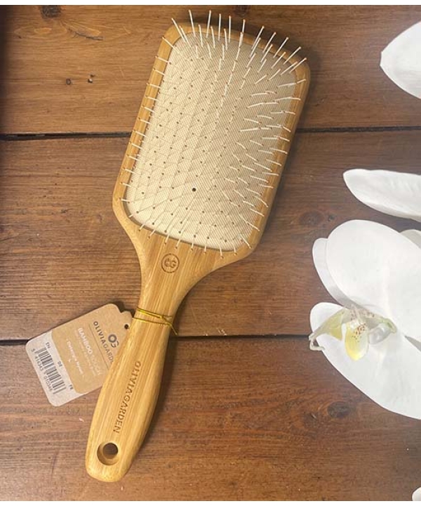 An Olivia Garden – Ionic Bambus Touch hårbørste - Detangle Nylon L - Padlebørste på et træbord.