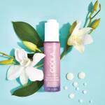 en flaske bodylotion, der sidder ved siden af en blomst.