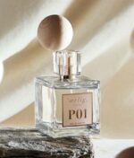 Glasflaske "Ærlig P01 - Eau de Parfum 100 ml glasflaske" med en trækuglehætte, placeret på en struktureret overflade med neutral baggrund.