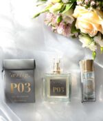 En udstilling af tre flasker "Ærlig P03 - Eau de Parfum 100 ml glasflaske" og en buket blomster på hvid stofbaggrund.