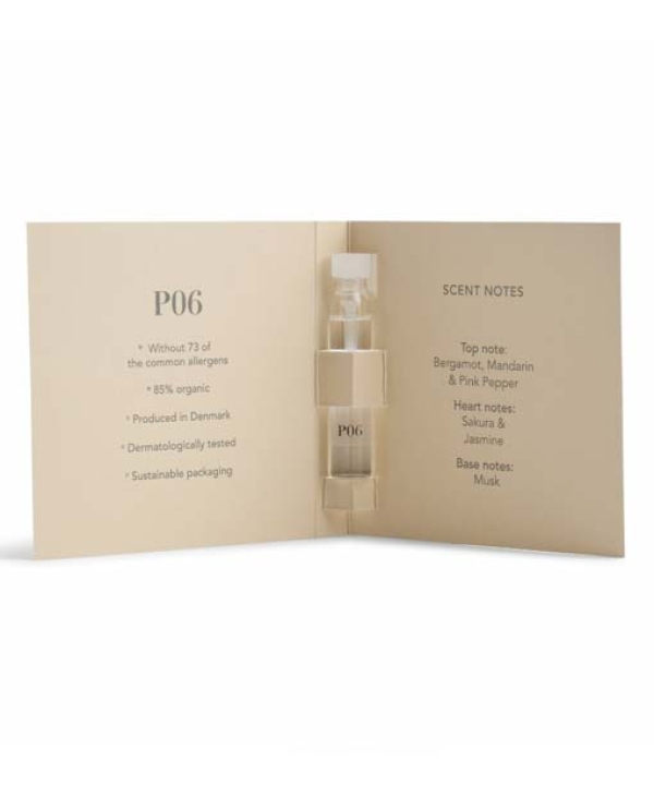 Et åbent hæfte med et lille parfumehætteglas mærket "P06" og duftnoter, herunder bergamot, mandarin, pink peber, sakura, jasmin og moskus. Tekst noterer produktets fordele og bæredygtig emballage fra **Ærlig Duftprøver - P01, P02, P03, P04, P05 & P06 6 x 1,3 ml**.