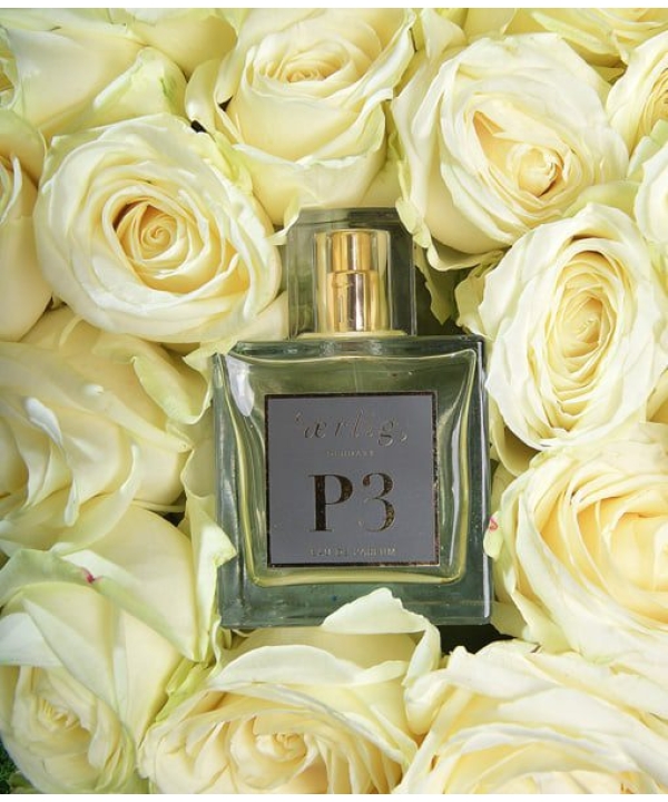 en flaske parfume omgivet af hvide roser.