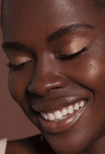 et nærbillede af en kvinde, der smiler med lukkede øjne.