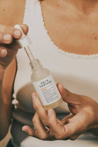 En kvinde holder en flaske serum.