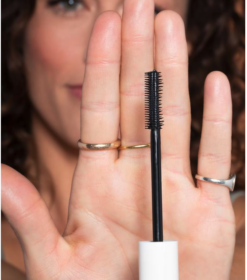 en kvinde med en mascara i hånden.