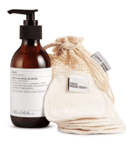 en flaske lotion ved siden af en stofpose.