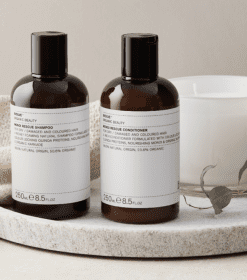 to flasker lotion siddende på et bord ved siden af en kop.
