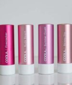 Fire COOLA Mineral Liplux® SPF30 - Nude Beach-rør i forskellige nuancer og mærket "Firecracker", "Nude Beach", "Summer Crush" og "Skinny Dip" er linet op mod en almindelig baggrund.