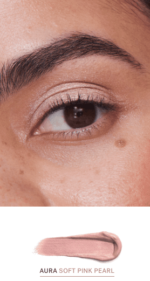et nærbillede af en persons øje med en pink eyeliner.