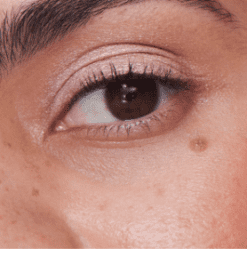 et nærbillede af en persons øje med en pink eyeliner.