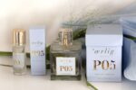 en flaske parfume ved siden af en æske parfume.