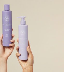 to hænder, der holder en flaske lavendellotion og en flaske lotion.
