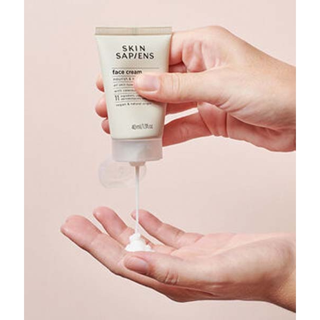En persons hånd holder en tube Skin Sapiens Face Cream 40 ml.