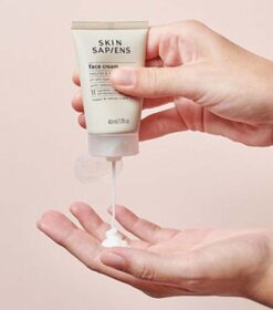 En persons hånd holder en tube Skin Sapiens Face Cream 40 ml.