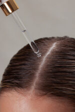 En kvindes hår bliver sprayet med Innersense Hair Renew Daily Active Serum 29 ml.