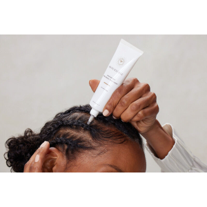 En kvinde påfører Innersense Hair Renew Daily Active Serum 29 ml i hendes hår.