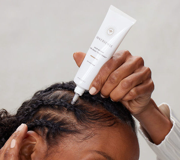 En kvinde påfører Innersense Hair Renew Daily Active Serum 29 ml i hendes hår.