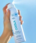 en kvinde holder en COOLA Mineral Body Spray Duftfri SPF 30 - 148 ml.