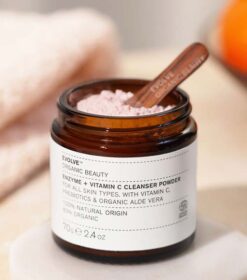 en krukke Evolve Organic Beauty Enzyme + Vitamin C Cleansing Powder 70 g siddende oven på en skål appelsiner.