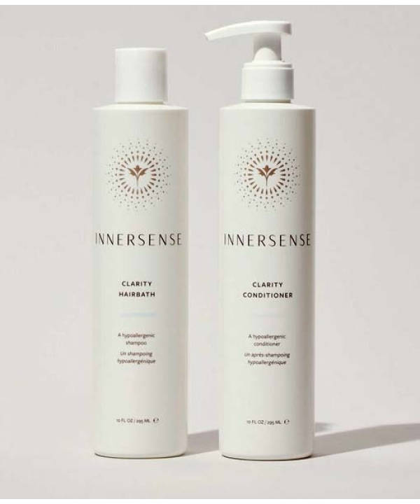 To hvide flasker med Innersense hårplejeprodukter vises: den ene mærket "Clarity Hairbath" og den anden "Clarity Conditioner", begge med et minimalistisk design. Sammen danner de Innersense Clear + Calm Clarity Duo - Hairbath & Conditioner for en rolig hårplejeoplevelse.