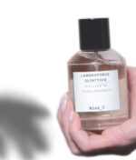 en kvinde med en flaske parfume.