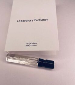 A Laboratory Parfumes Gorse Parfumeprøve 2 ml siddende ved siden af en bog.