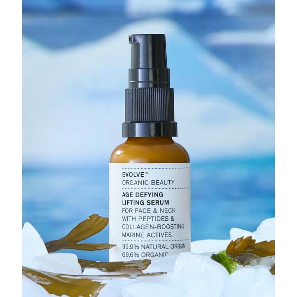En flaske Evolve Organic Beauty Age Defying Lifting Serum 30 ml siddende på en bunke is.