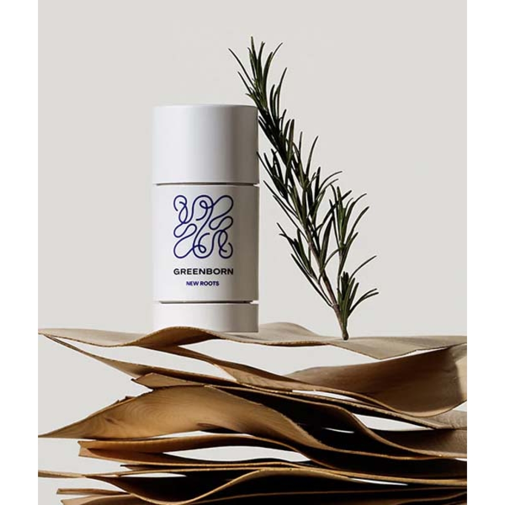 En Green Born Deo Stick New Roots 50 g siddende oven på en stak papirer.