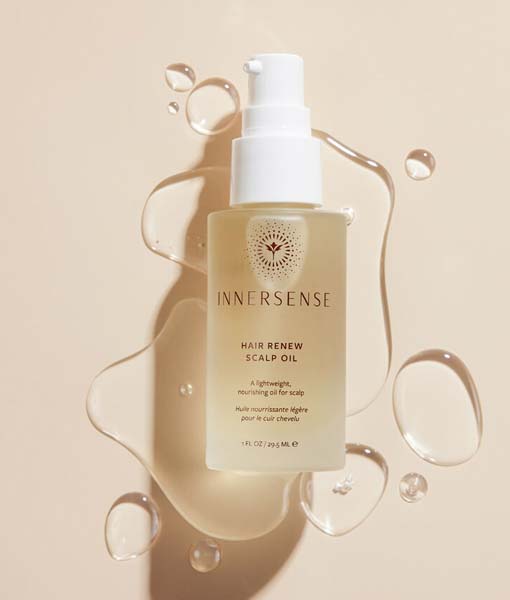 En flaske Innersense Hair Renew Scalp Oil 29 ml på en beige baggrund.