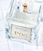 Klar glasflaske "Ærlig P06 – Eau de Parfum 15 ml glasflaske Roll on TRAVEL" med guldhætte og etiket, placeret på en hvid struktureret overflade.