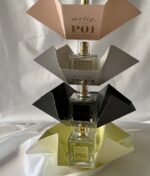 Udstilling af fire flasker parfume mærket Ærlig P06 – Eau de Parfum 15 ml glasflaske Roll on TRAVEL anbragt på dekorative papirholdere i forskellige farver.