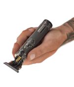 En person, der holder en EFALOCK Professional Bad Butch - Præcisions hårtrimmer med en tatovering på.