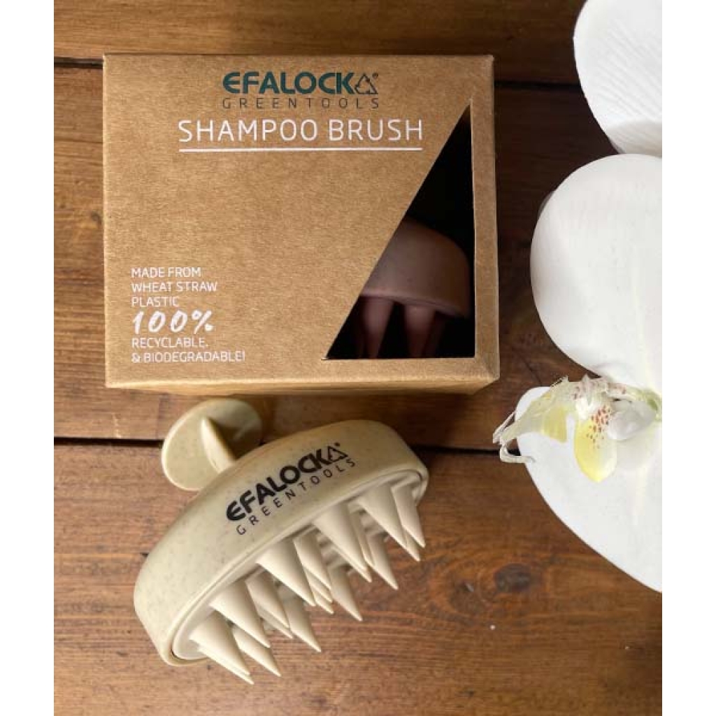 EFALOCK Shampoo Brush Rose på et bord ved siden af en blomst.