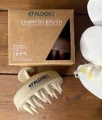 EFALOCK Shampoo Brush Rose på et bord ved siden af en blomst.