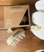 EFALOCK Shampoo Brush Rose - 100% hvedestrå plastik på et bord ved siden af en kasse med blomster.