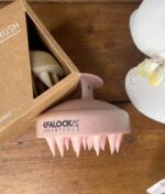 En EFALOCK Shampoo Brush Rose - 100% hvedestrå plastik blomst i en æske ved siden af et træbord.