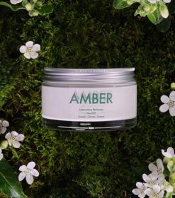 En krukke med Laboratory Parfums Amber Creme nr. 001, 200 ml omgivet af mos og blomster.