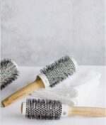 Tre Olivia Garden Bamboo Touch Blowout rundbørste termisk 63 mm på en hvid overflade.