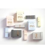 Forskellige Ærlig P05 – Eau de Parfum 15 ml glasflaske Roll on TRAVEL æsker mærket med forskellige koder (P01, P02 osv.) vises på hvid baggrund. Farverne på kasserne inkluderer pink, guld, sort, lyseblå og beige.