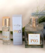 Billedet viser tre varer fra en parfumeproduktlinje mærket "Ærlig P05 – Eau de Parfum 15 ml glasflaske Roll on TRAVEL" af "ærlig." Fra venstre mod højre: en roll-on flaske, en rektangulær produktkasse og en firkantet glassprayflaske. Græs er i baggrunden.
