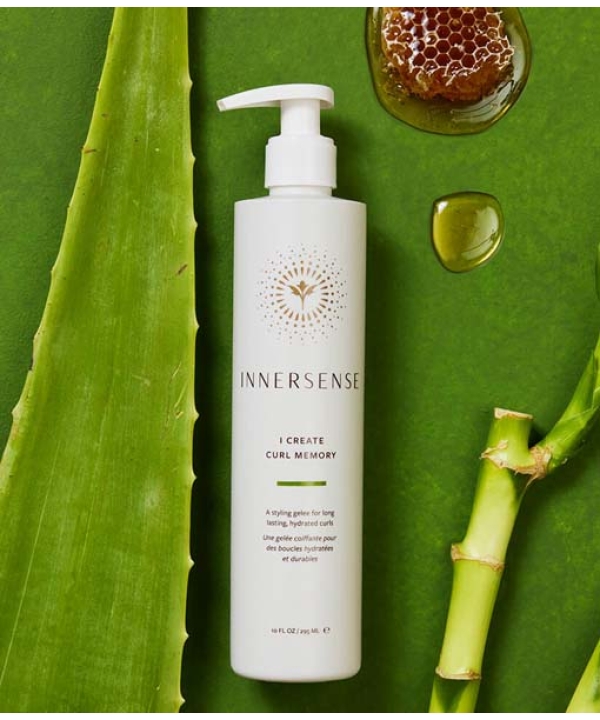 En flaske Innersense I Create Curl Memory - Hydrating Styling Gel 295 ml på en grøn baggrund.