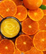 En skål Evolve Miracle Vitamin C Mask 60 ml omgivet af friske appelsinskiver.